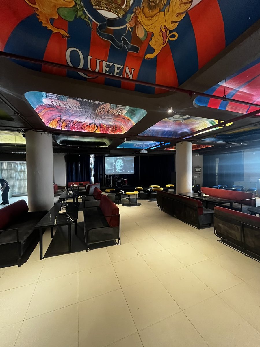 Tatsav lounge area with projector screen and ceiling murals